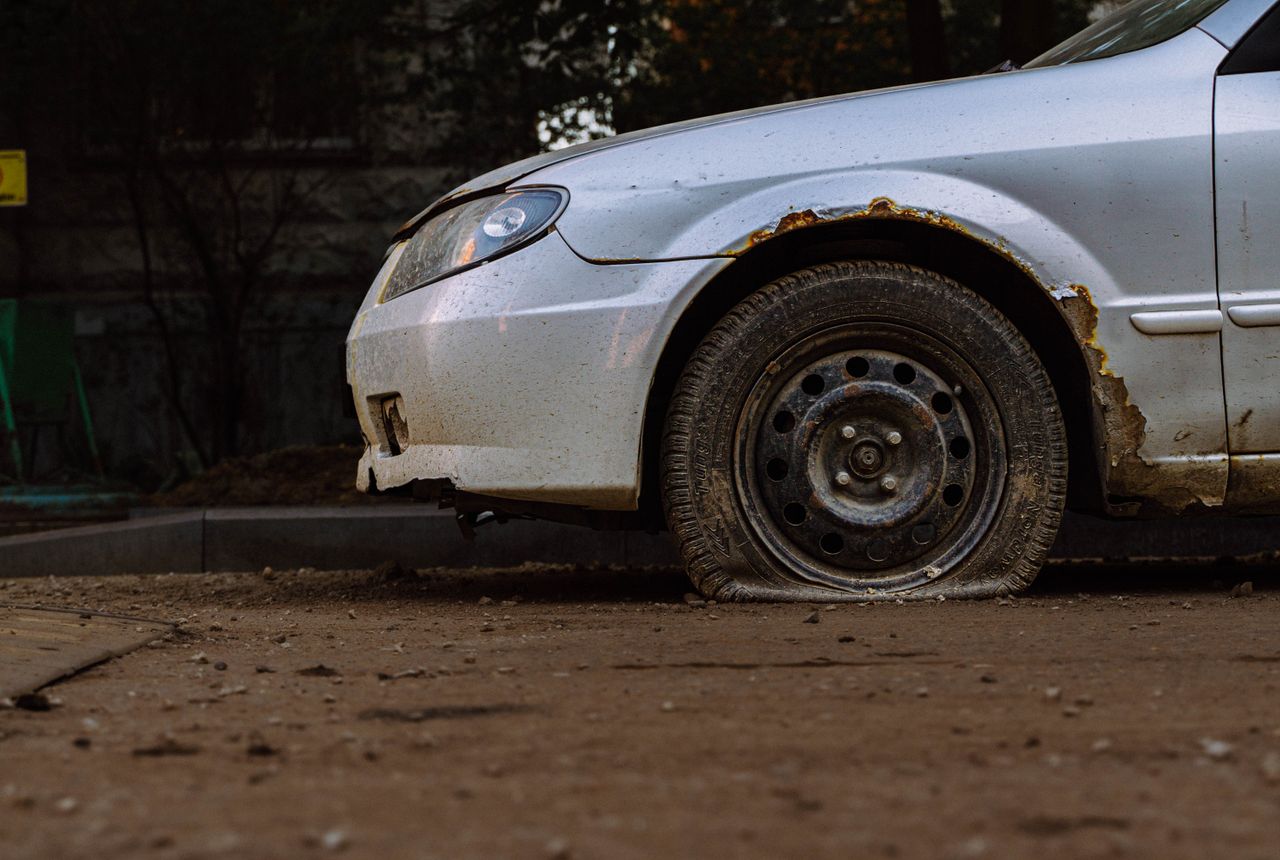 Car with a flat tire in Calgary waiting for roadside tire service